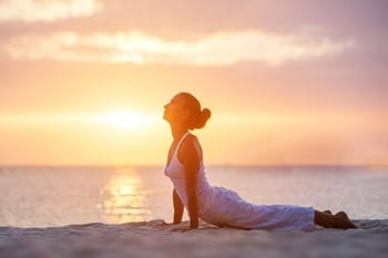 Caucasian woman practicing yoga at seashore Caucasian woman practicing yoga at seashore